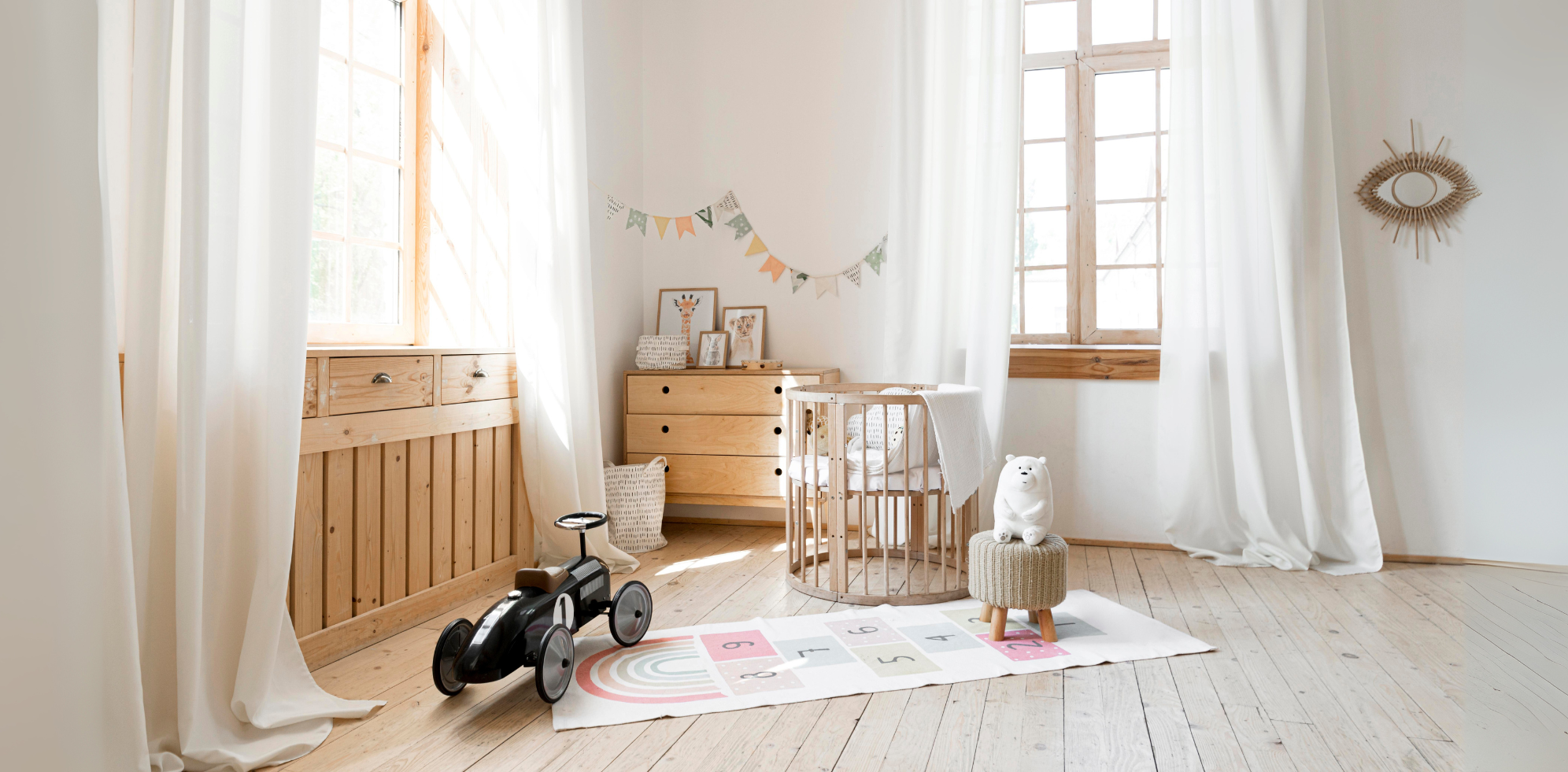 Nursery room with wooden furniture, crib, and toys in a bright room.