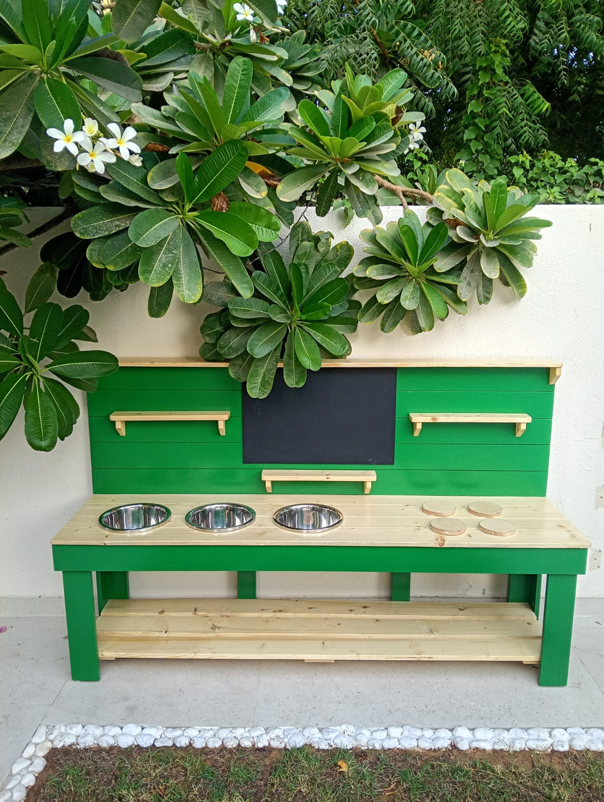 mud kitchen with stainless steel bowls, shelves, blackboard, and stove